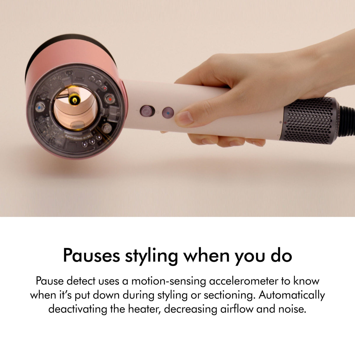 A hand holds a Dyson Supersonic Nural hair dryer with a transparent head, revealing internal sensors for intelligent drying.