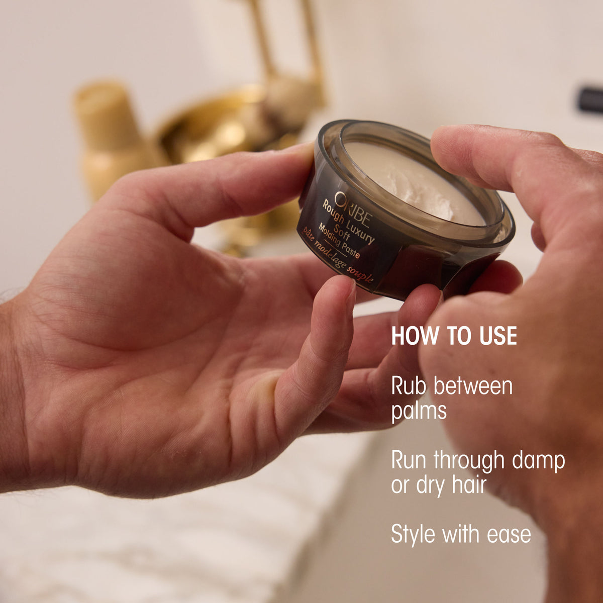 Hands hold an open jar of Oribe Rough Luxury Soft Molding Paste, with text explaining how to rub the product between palms and apply to damp or dry hair for texture and style.
