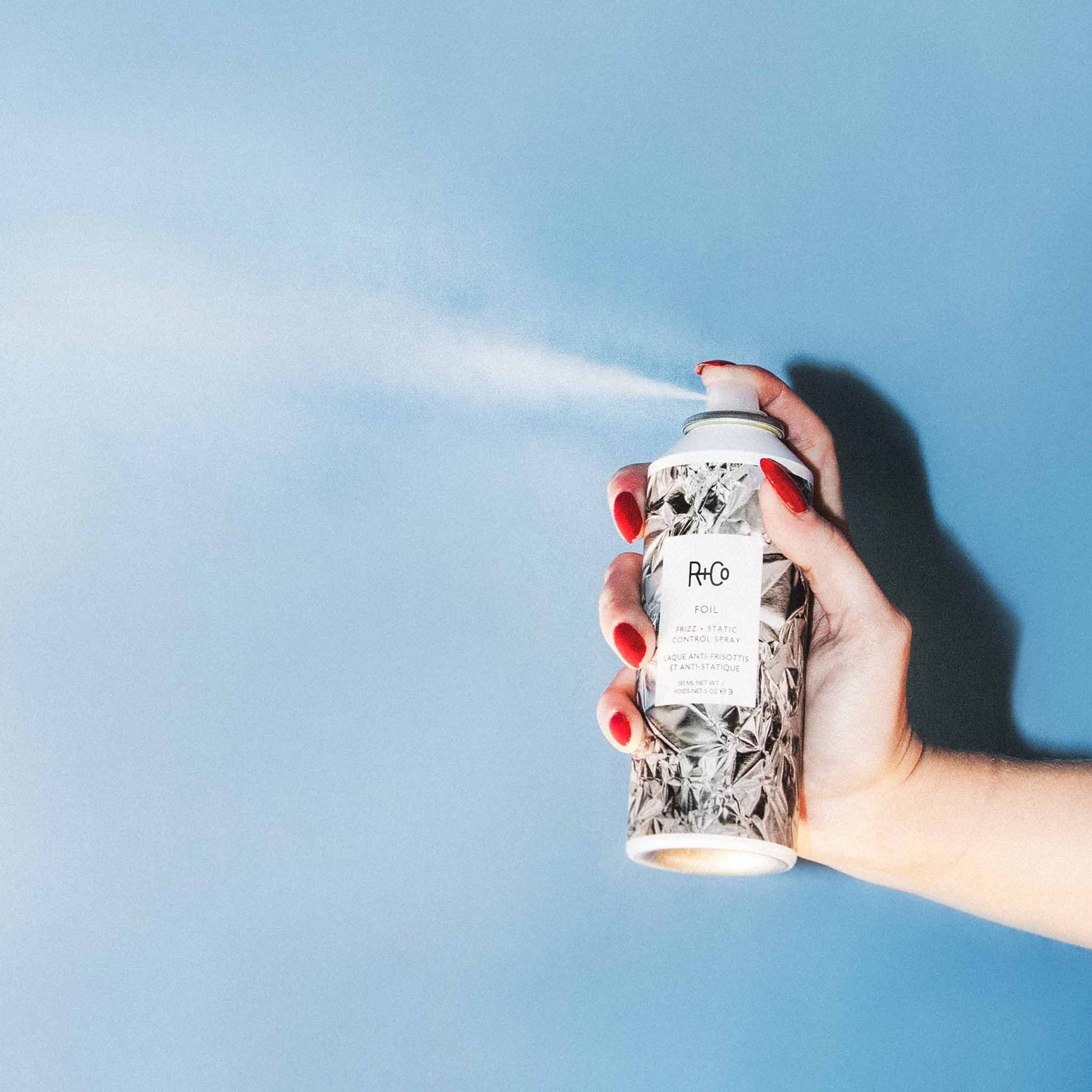Lifestyle image of R+Co Foil Frizz and Static + Control Spray