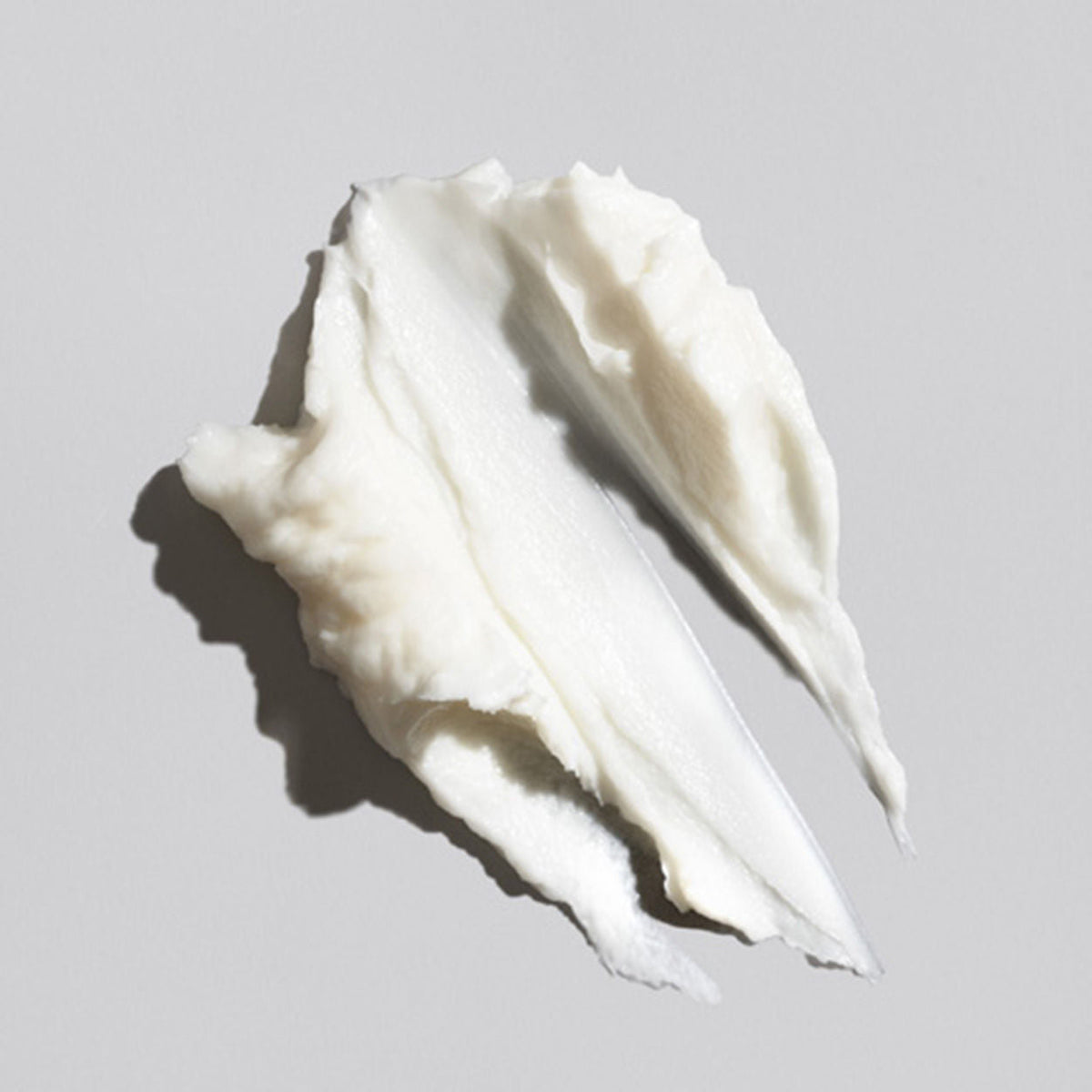 A smooth, hydrating smear of thick white Oribe Signature Moisture Deep Conditioning Hair Masque.