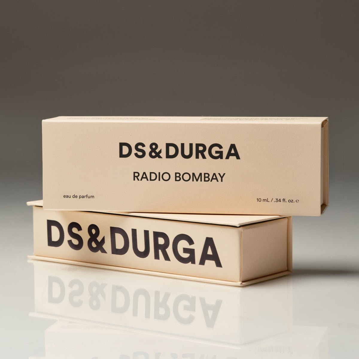 Two beige rectangular D.S. & Durga Radio Bombay Eau de Parfum boxes stacked on a reflective surface with the brand and product names printed in black text on the front.