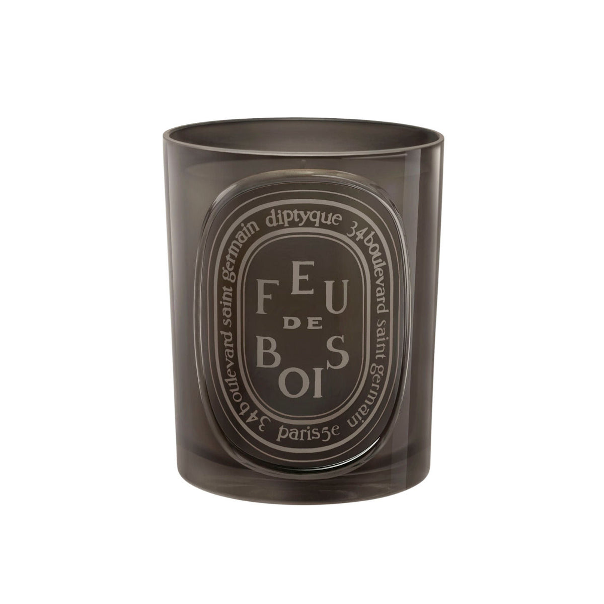 A gray glass Diptyque Feu de Bois (Wood Fire) Candle with an oval label printed with the words FEU DE BOIS, evoking the scent of a burning wood fireplace.