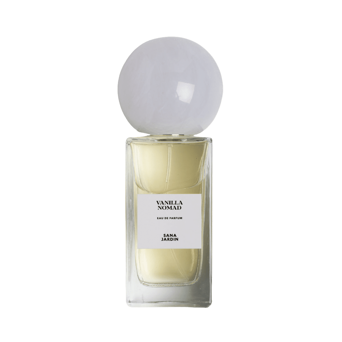 A rectangular glass bottle of Sana Jardin Vanilla Nomad Eau de Parfum filled with pale yellow fragrance, topped with a large, spherical white cap and featuring a white label with black text.