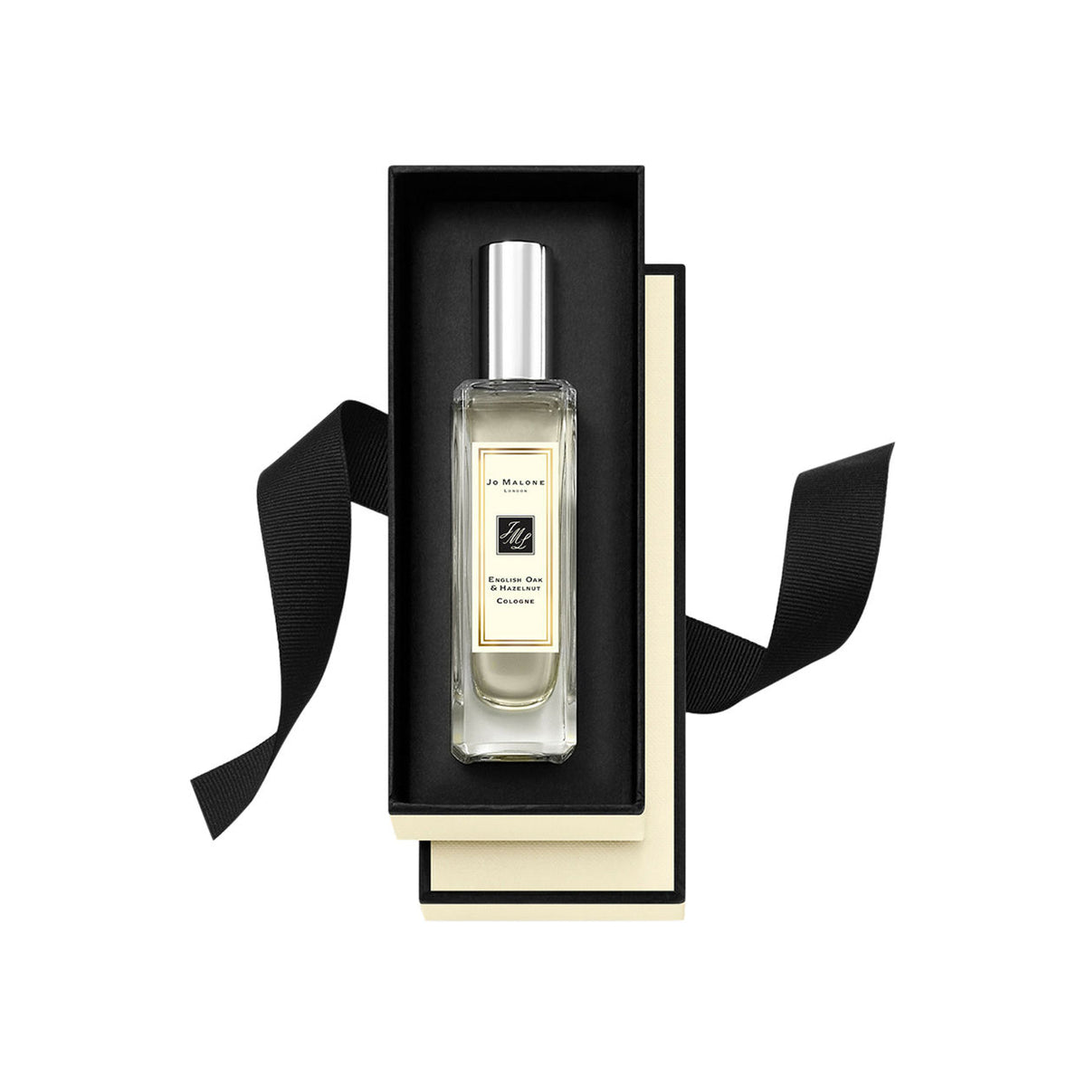 A rectangular English Oak and Hazelnut Cologne bottle with a silver cap sits inside an open black and cream box tied with a black ribbon.