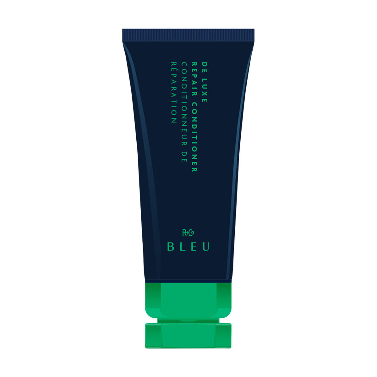 A dark blue squeeze tube of R+Co Bleu De Luxe Reparative Conditioner with a bright green cap, labeled in English and French, designed for deep hydration of damaged hair.