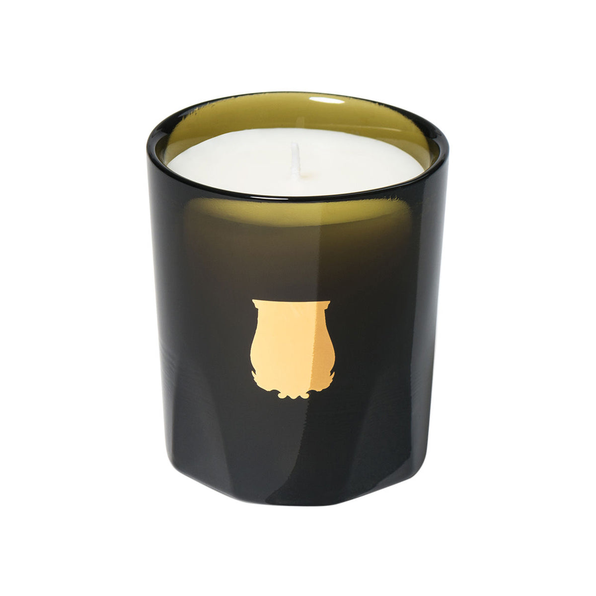 An Abd El Kader candle in a dark green glass vessel with a gold emblem on the front.