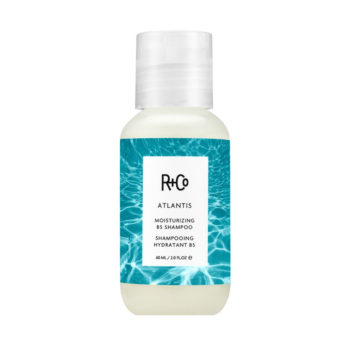 Travel-size bottle of R+Co Atlantis Moisturizing B5 Shampoo with a label featuring a blue water pattern, ideal for dry hair.