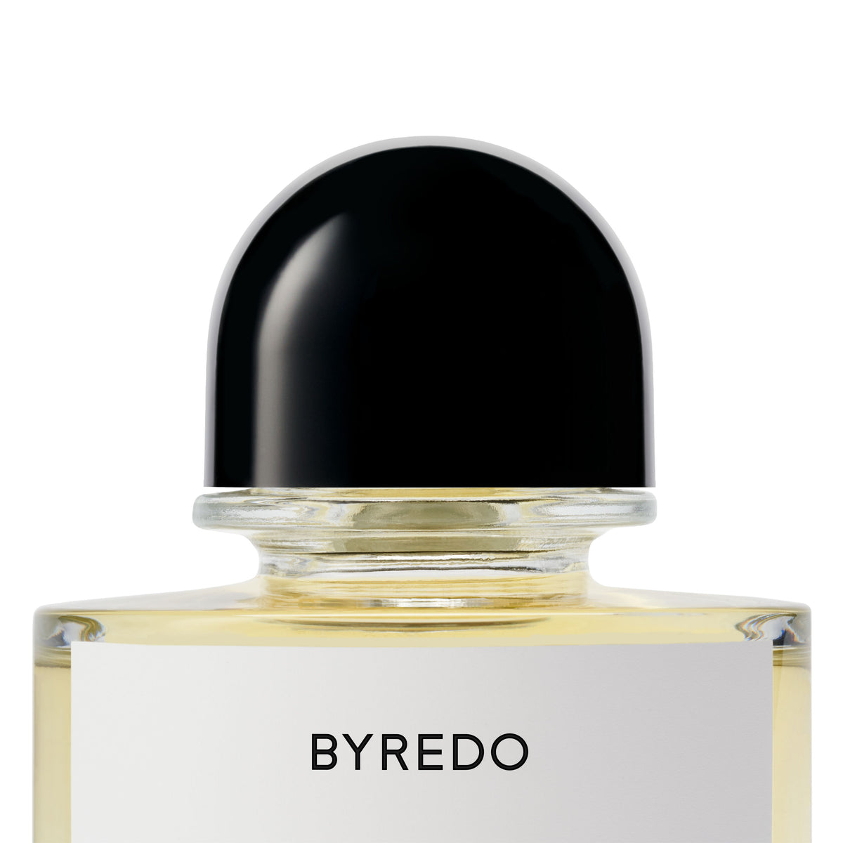 Close-up of a clear glass Byredo Future Memories Eau de Parfum bottle with a black domed cap and a white label, evoking textured vanilla and powdery iris.
