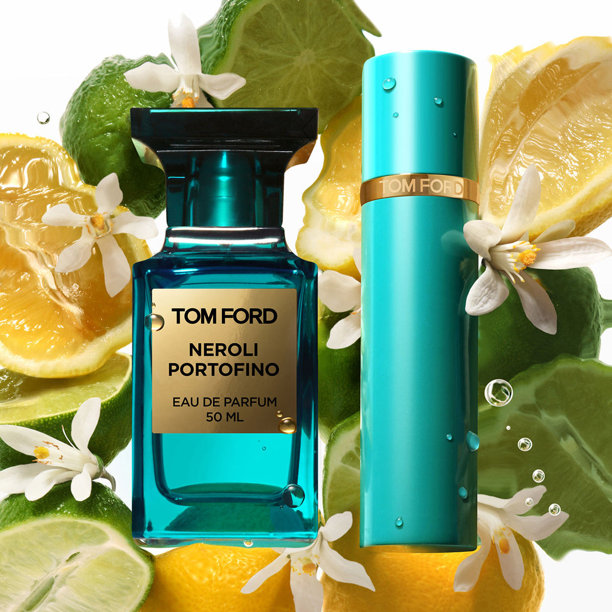 A rectangular teal Neroli Portofino Eau de Parfum Spray bottle and a matching cylindrical spray bottle surrounded by sliced lemons, limes, and white blossoms with citrus oils.
