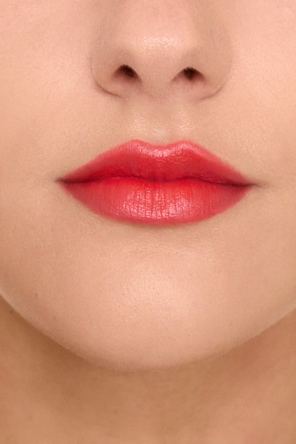 Close-up of a person’s mouth wearing Trish McEvoy Easy Lip Color in a luxurious bright red shade.