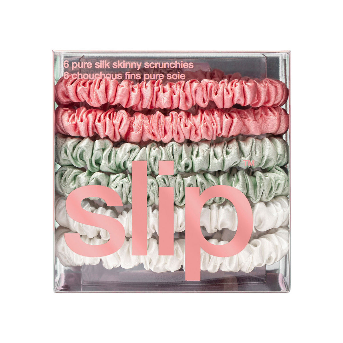 A clear box containing six Slip Pure Silk Skinny Scrunchies in shades of pink, mint green, and white.
