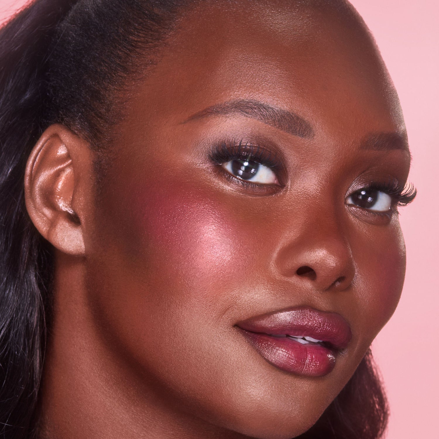 Model image of Charlotte Tilbury Unreal Lip + Cheek Glow Blush Stick with Hyaluronic Acid variant: Berry Glow