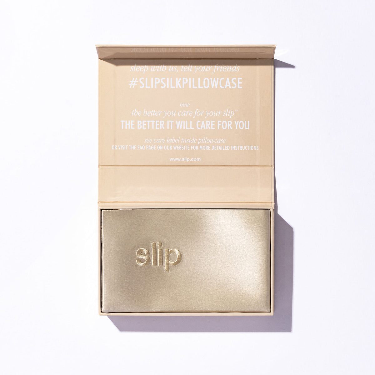 A gold Slip Pure Silk Queen Pillowcase inside an open gift box featuring printed care instructions on the inside lid.