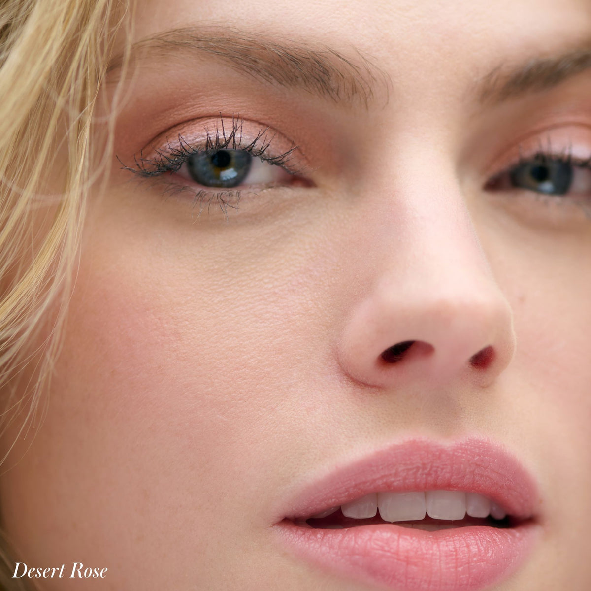 Close-up of a person wearing soft pink Cashmere Matte Eyelights and matching lipstick, with the text Desert Rose in the bottom left corner.
