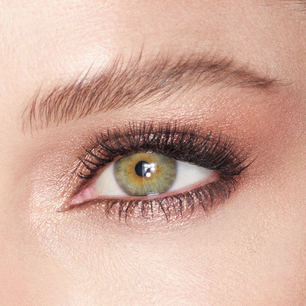 Close-up of an eye wearing Charlotte Tilbury Eyes To Mesmerise in metallic bronze cream eyeshadow and mascara.
