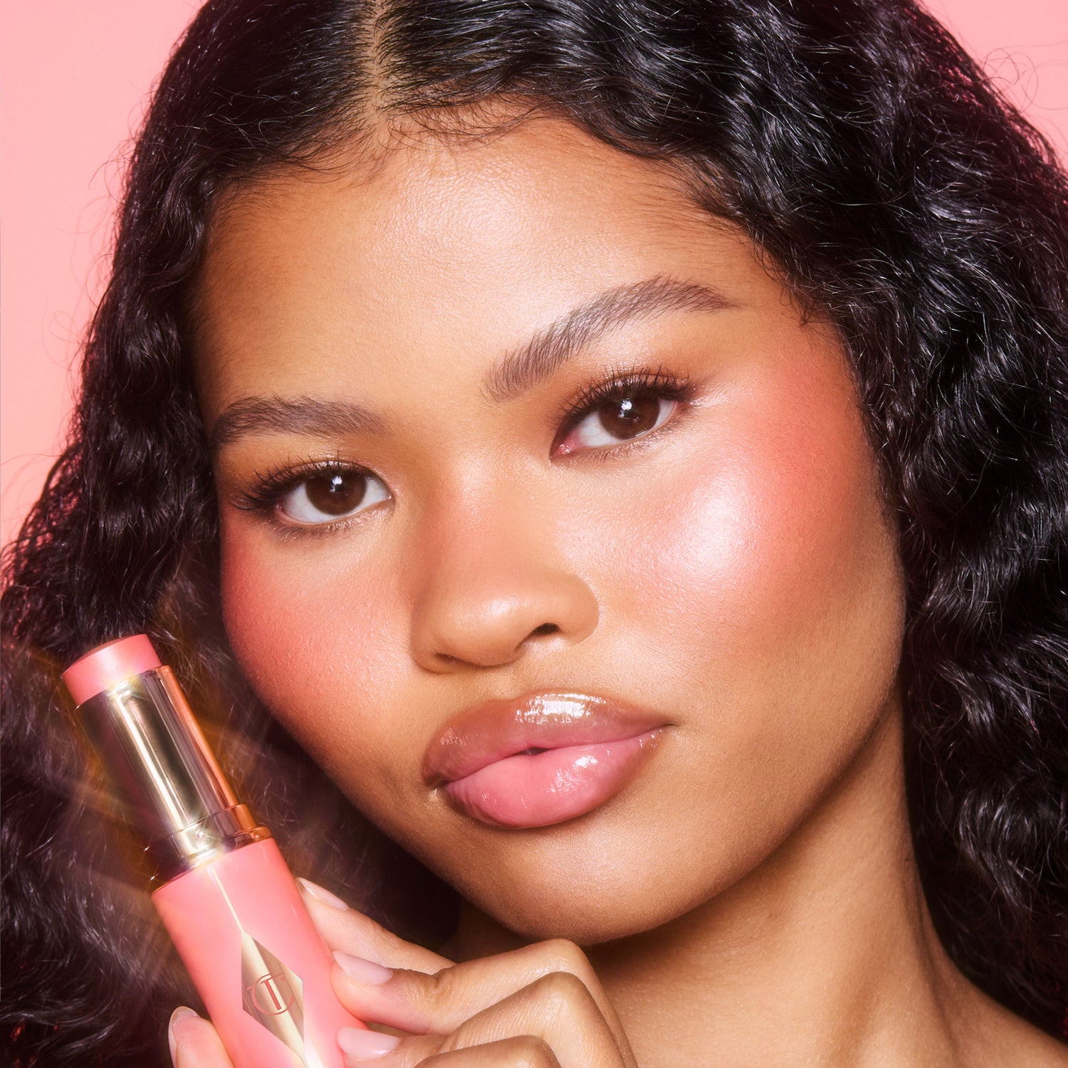 Model image of Charlotte Tilbury Unreal Lip + Cheek Glow Blush Stick with Hyaluronic Acid variant: Peachy Glow