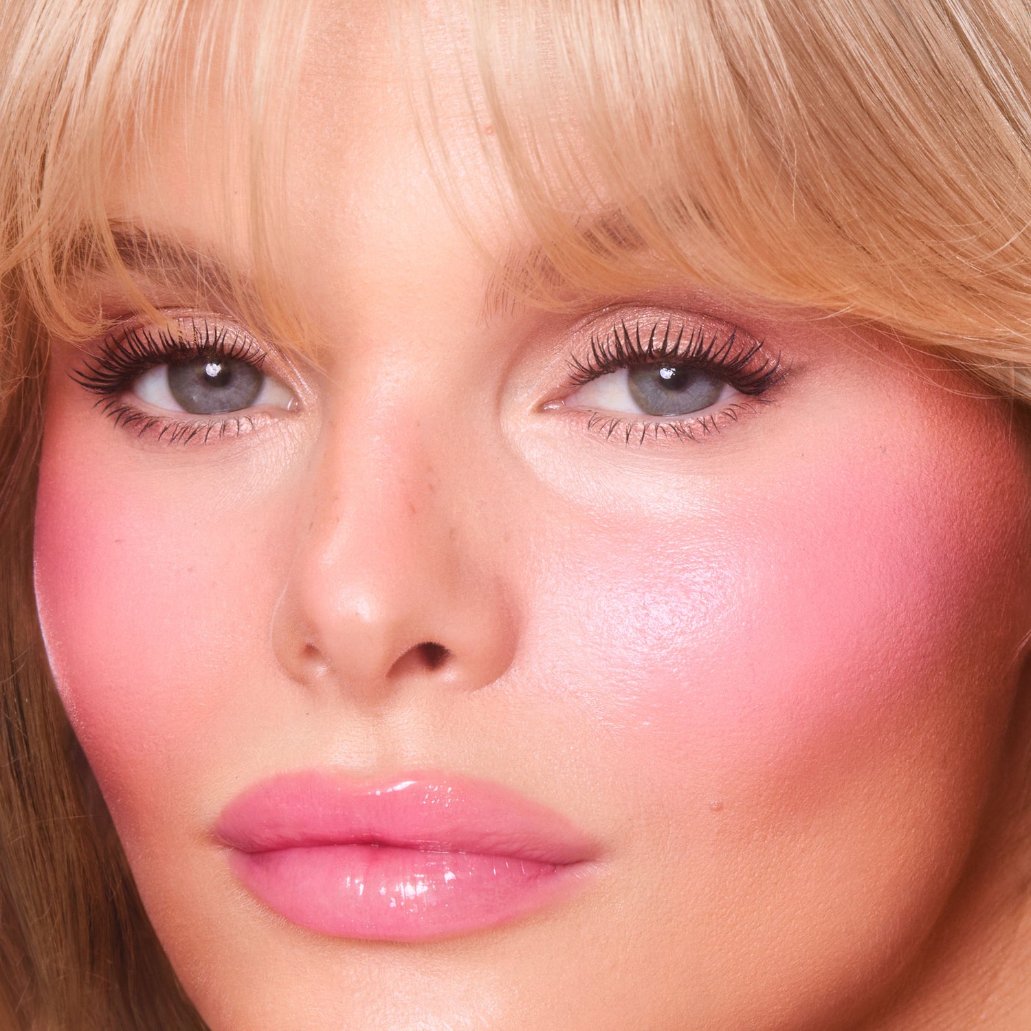 Model image of Charlotte Tilbury Unreal Lip + Cheek Glow Blush Stick with Hyaluronic Acid variant: Pinky Glow