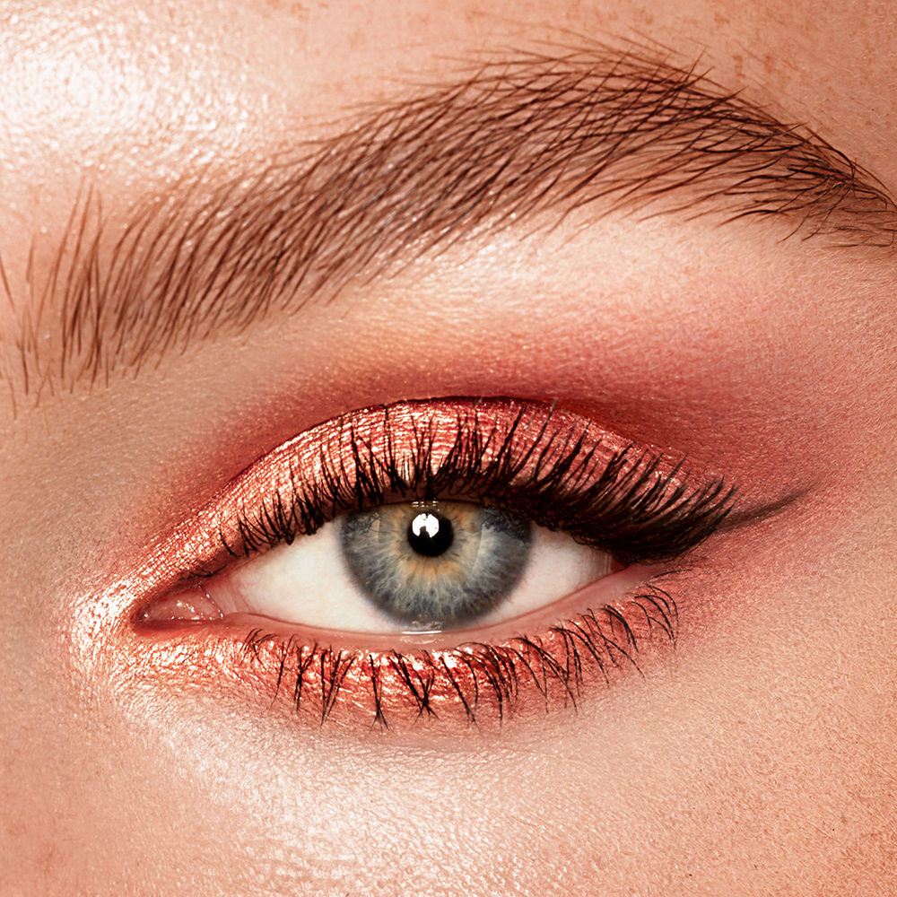 A close-up of an eye wearing shimmering copper Charlotte Tilbury Eyes To Mesmerise cream eyeshadow and dark eyeliner.