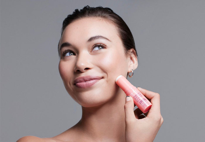 woman applying skincare stick