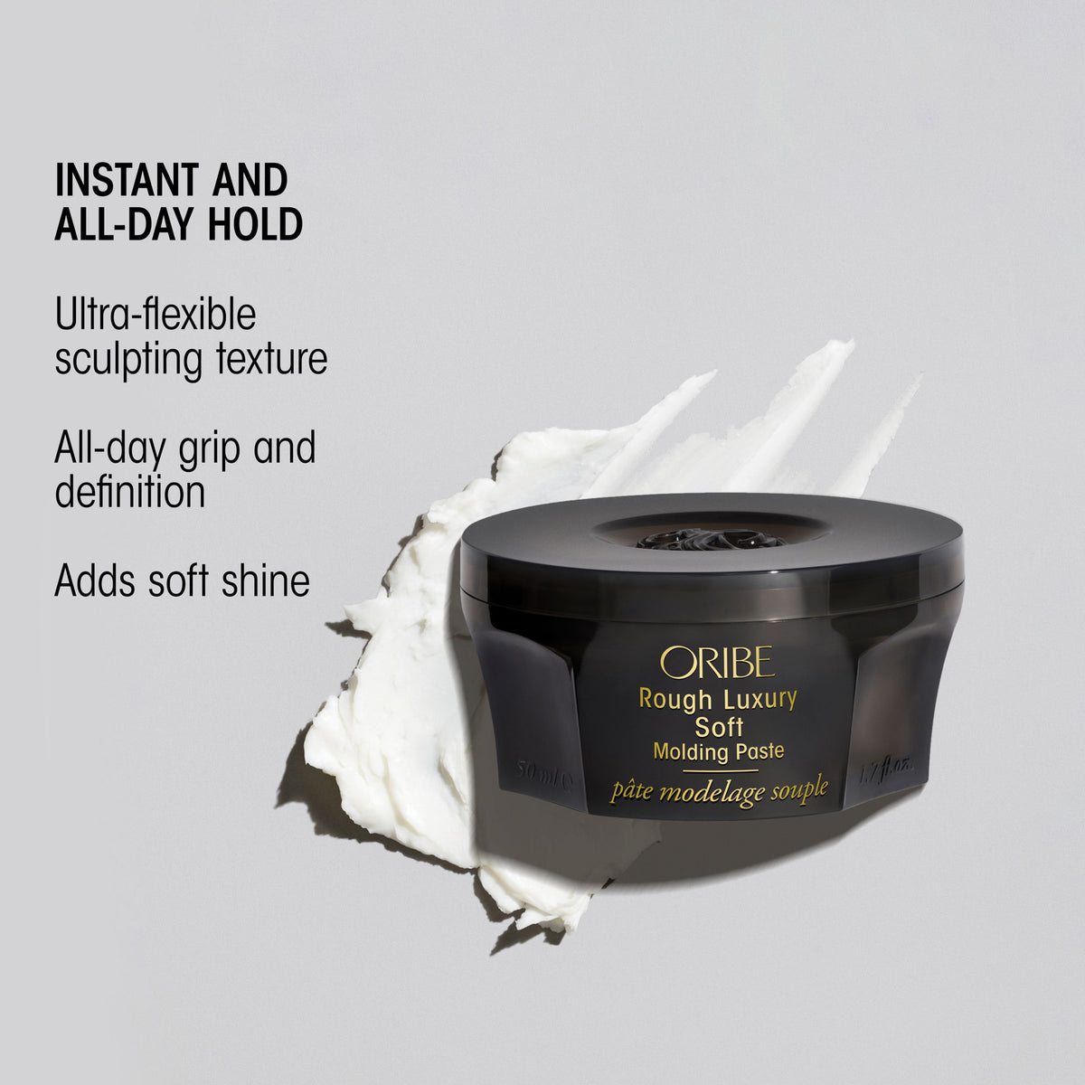 Oribe Rough Luxury Soft Molding Paste in a black jar centered on a gray background, with a white cream smear behind it and text listing benefits: instant, flexible hold for hair texture, all-day grip, and soft shine.