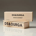 Two beige rectangular D.S. & Durga Radio Bombay Eau de Parfum boxes stacked on a reflective surface with the brand and product names printed in black text on the front.