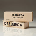 Two stacked light beige rectangular Black Magenta Eau de Parfum boxes with black lettering.