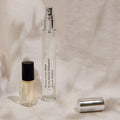A small square perfume oil bottle with a black cap and a tall, slender spray bottle with a silver cap of Maison Louis Marie No.04 Bois de Balincourt Eau de Parfum, evoking the fresh scent of rain-drenched forests.