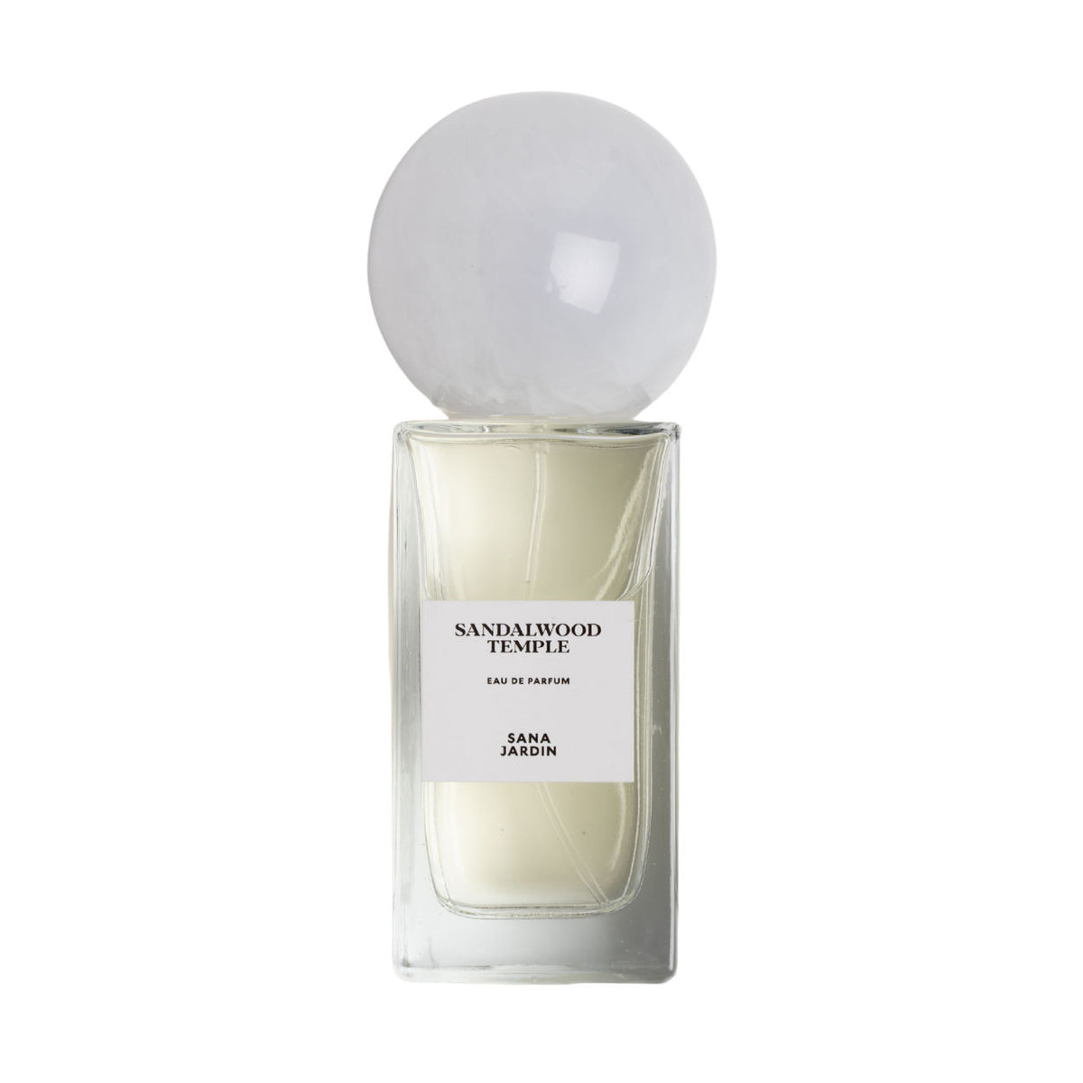 A rectangular bottle of Sana Jardin Sandalwood Temple Eau de Parfum filled with pale liquid and topped with a large, translucent spherical cap.