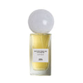 A rectangular glass bottle of Sana Jardin Revolution De La Fleur Eau de Parfum, filled with yellow liquid, topped with a large, spherical white cap and a label reading Eau de Parfum.