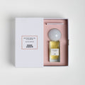 A rectangular Sana Jardin Revolution De La Fleur Eau de Parfum bottle with a round cap nestled in a pink-lined white gift box, both featuring labels with the product name and brand.