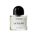 A glass bottle of Byredo La Tulipe Eau de Parfum with a black domed cap, featuring a minimalist white label and hints of freesia.