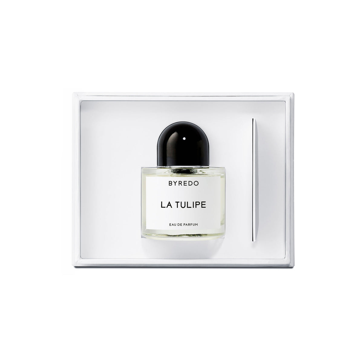 A glass bottle of Byredo La Tulipe Eau de Parfum with a black cap sits in a white box next to a thin applicator stick.