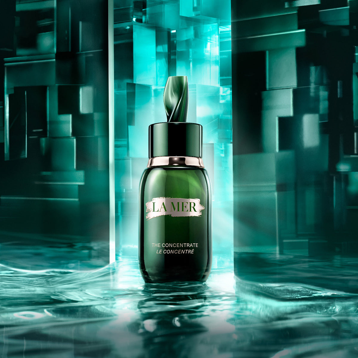 A dark green glass bottle of La Mer The Concentrate with a sculptural dropper cap standing on a reflective, rippled surface against a geometric, illuminated background.