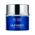 A small, round jar of La Prairie Skin Caviar Luxe Cream with a reflective silver lid and deep blue base.