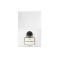 A glass Gypsy Water Absolu de Parfum bottle with a black cap, resting inside an open white box.