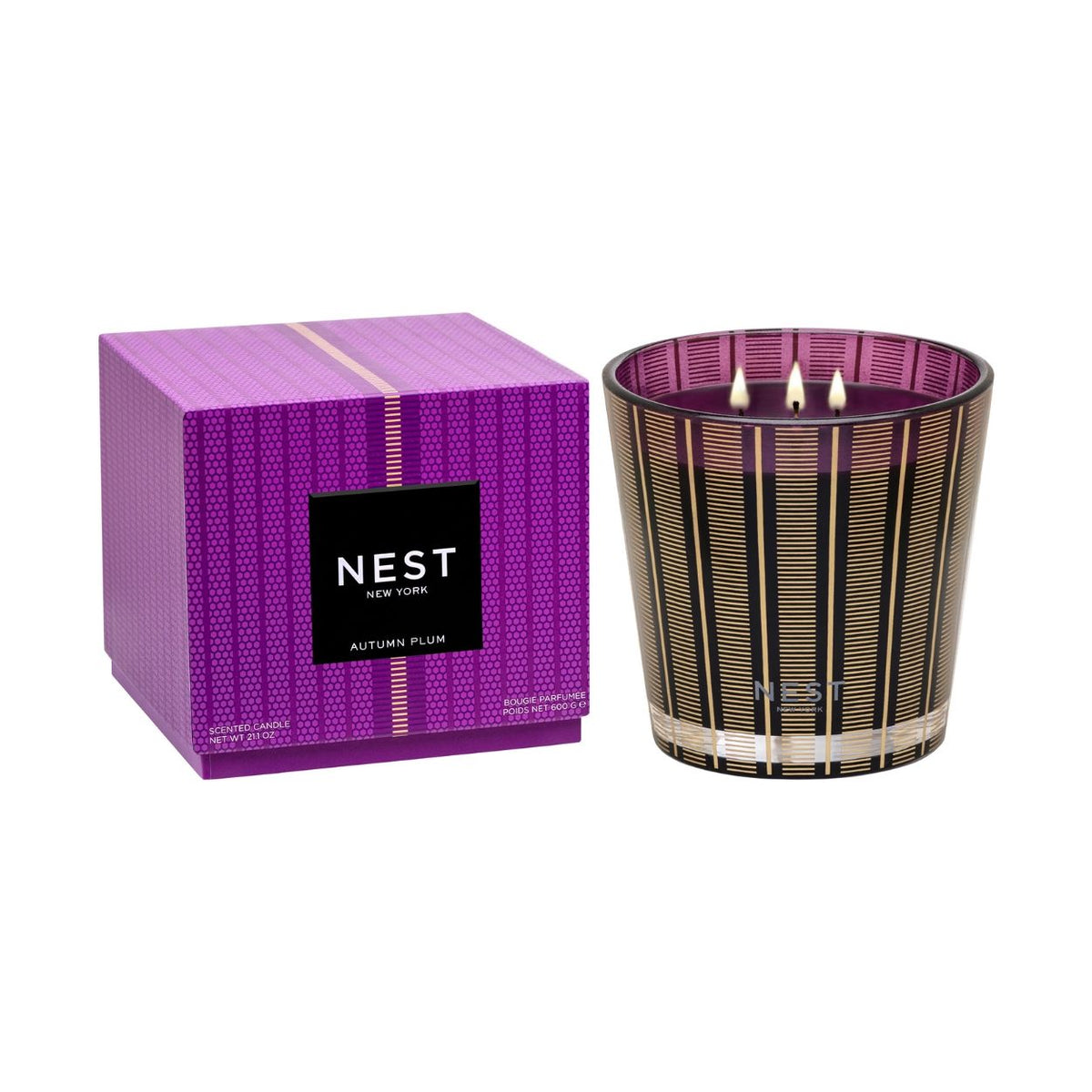 A three-wick Autumn Plum Candle (Limited Edition) in a purple and gold striped glass jar next to its matching purple patterned box.