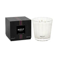 A black square box next to a Moroccan Amber Candle in a clear textured glass vessel.