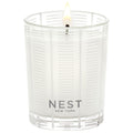 A lit Nest New York Forest Rain Candle in a clear glass vessel with a striped pattern, capturing the essence of dewy fig leaves.
