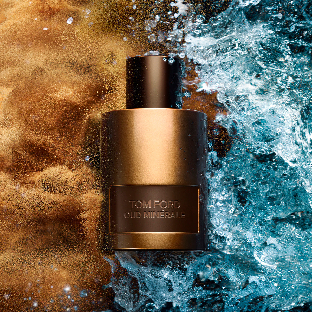 A cylindrical Tom Ford Oud Minerale Eau de Parfum bottle centered between a splash of water on the right and a mysterious cloud of golden powder on the left.