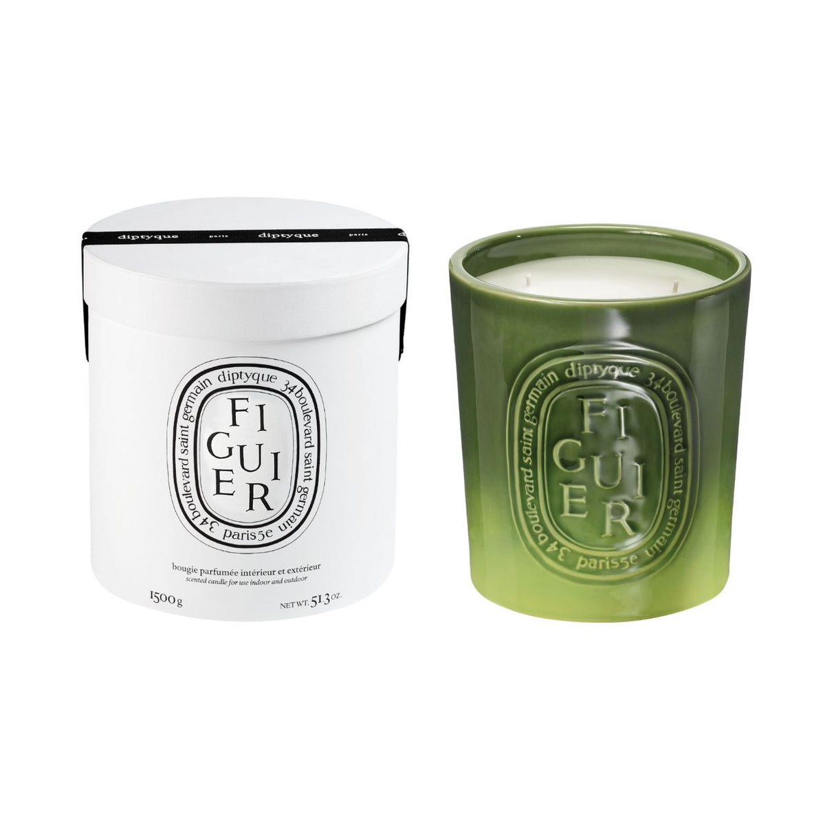 A white cylindrical Diptyque Figuier (Fig Tree) Candle box next to a green glass candle, both featuring an oval label with the text FIGUIER, evoking a fig orchard.
