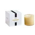 A white Chamomile Lavender Candle box with a black ribbon and a gold-toned label, next to a matching glass-vessel candle.