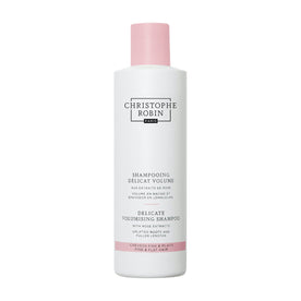 Christophe Robin Delicate Volumising Shampoo with Rose Extracts in a white bottle with a pink cap and black text describing how it creates fuller hair for fine and flat hair.