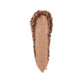 A smear of Bobbi Brown Highlighting Powder in metallic bronze, showing a radiant glow.