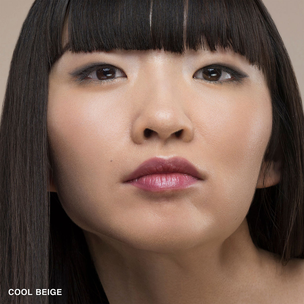 Close-up of a woman’s face wearing Bobbi Brown Skin Foundation Stick in a smooth, natural-looking finish, with the text COOL BEIGE in the bottom-left corner.