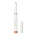 A champagne-colored Jane Iredale ColorLuxe Eye Shadow Stick with a white cap standing next to its removed lid.