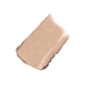 A diagonal swatch of shimmering champagne-colored ColorLuxe Eye Shadow Stick cream-to-powder eye shadow.