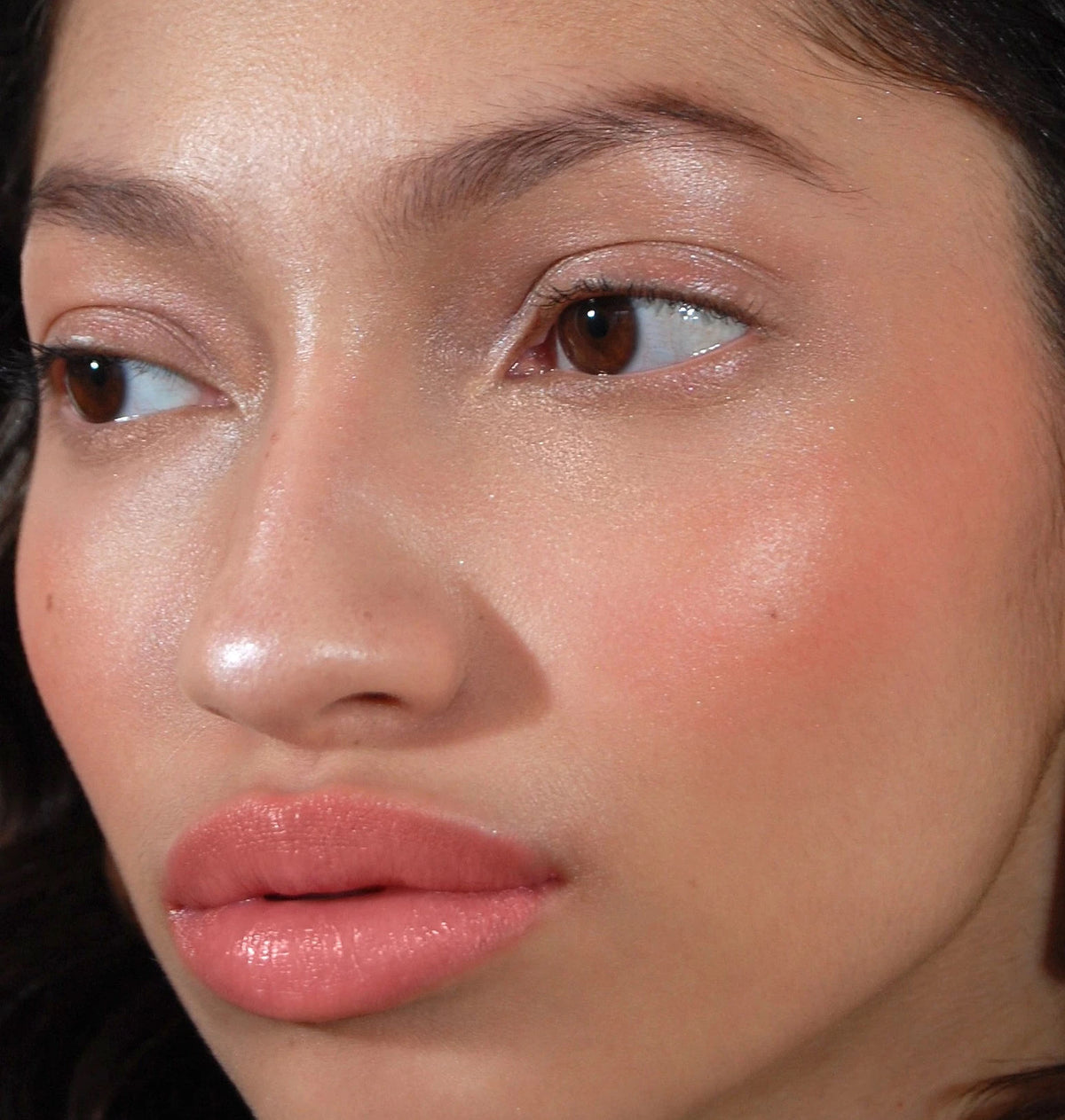 Close-up of a person wearing peach-toned Going Rouge Cream Cheek and Lip on their cheeks and lips.