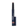 A Lune+Aster Dawn to Dusk Cream Eyeshadow Stick in a dark blue casing with the cap removed, revealing a neutral-toned, pigmented product tip.