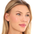 A woman with fair skin wears an effortless swipe of soft pink Fast-Track Lip & Cheek on her lips and cheeks.